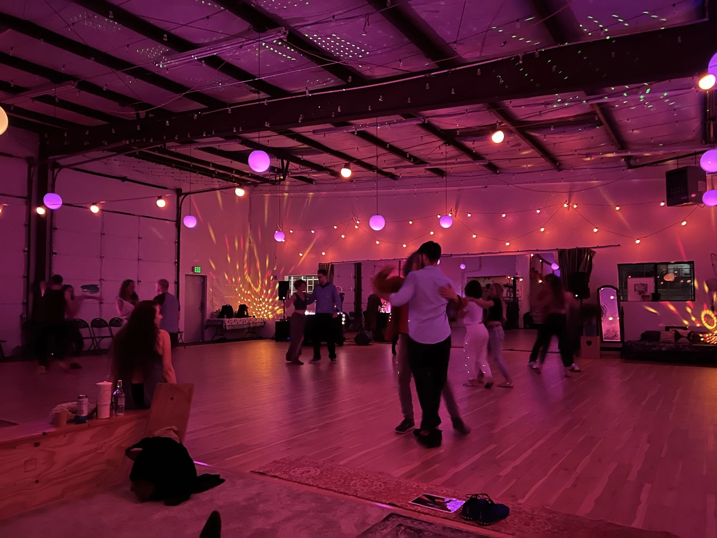 Dancers under pink and purple lights at the Hut Warehouse